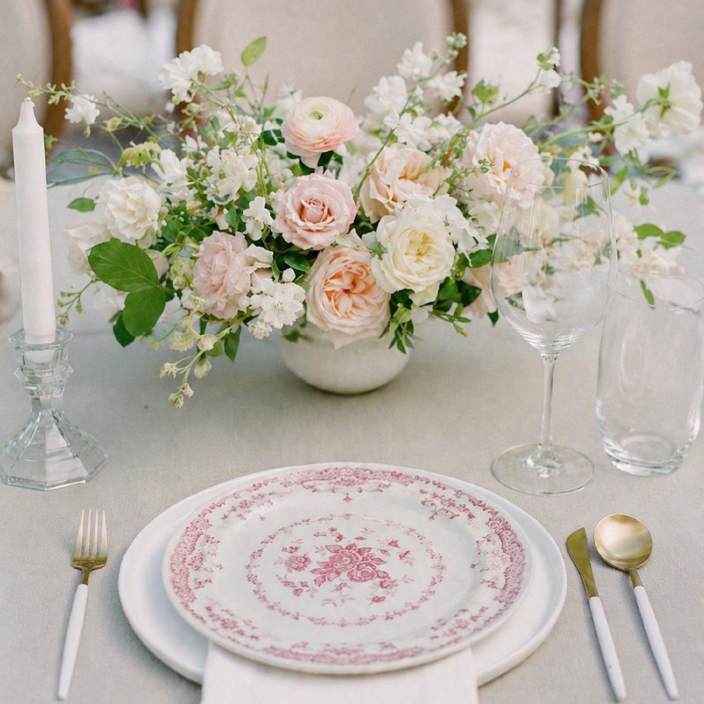 Rosewater small still-life centerpiece with blush and ivory garden blooms arranged in a ceramic bowl on a reception table.