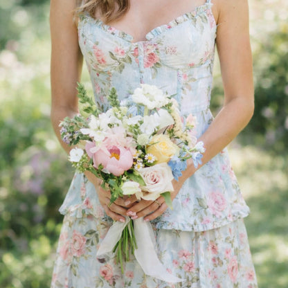Pastel bridesmaid bouquet with blush, blue, cream, and soft garden flowers.