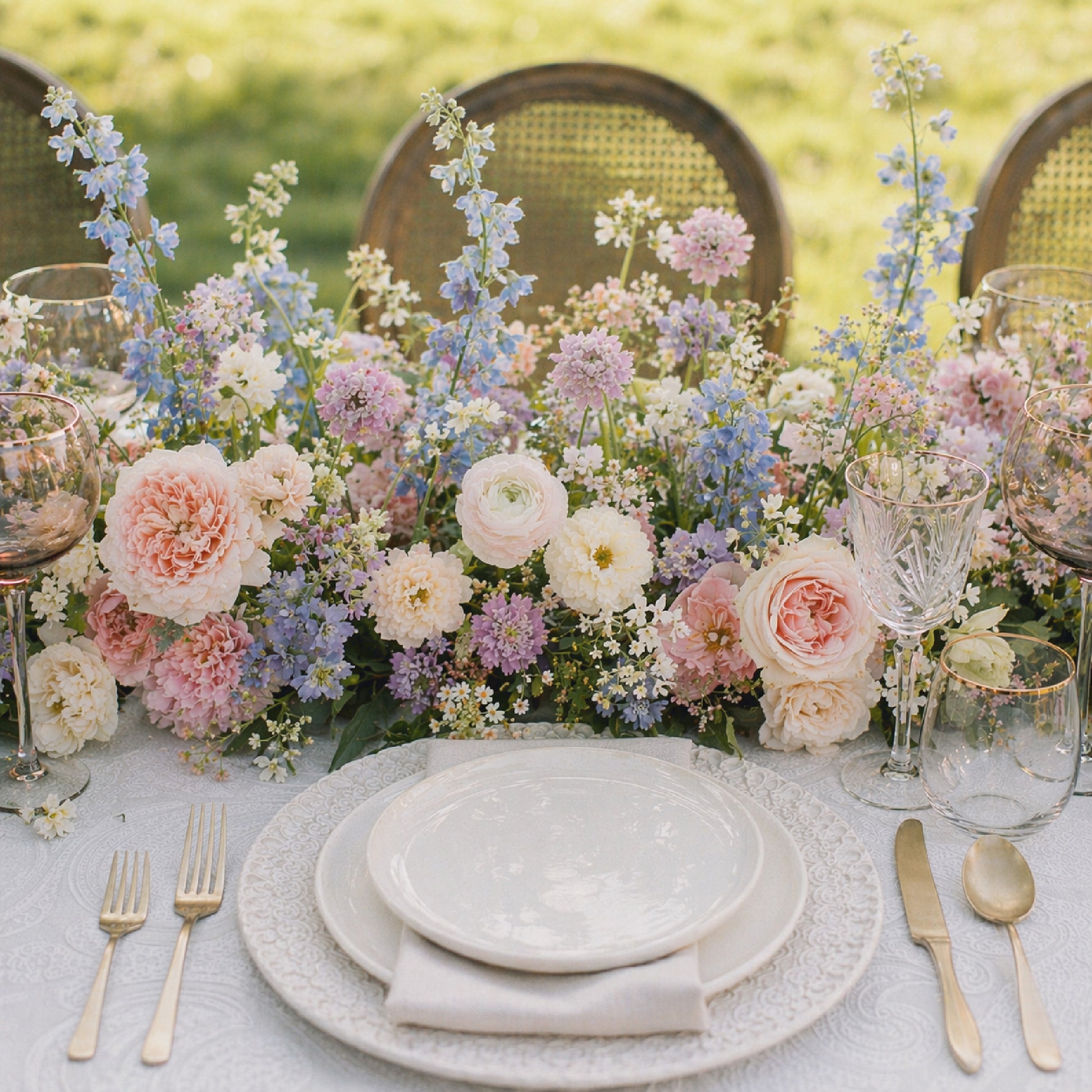 Pastel floral runner centerpiece with blush, lavender, blue, cream, and white garden flowers
