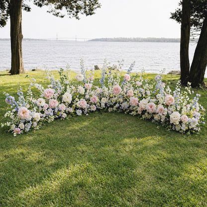 Pastel ground meadow flowers framing romantic outdoor wedding ceremony