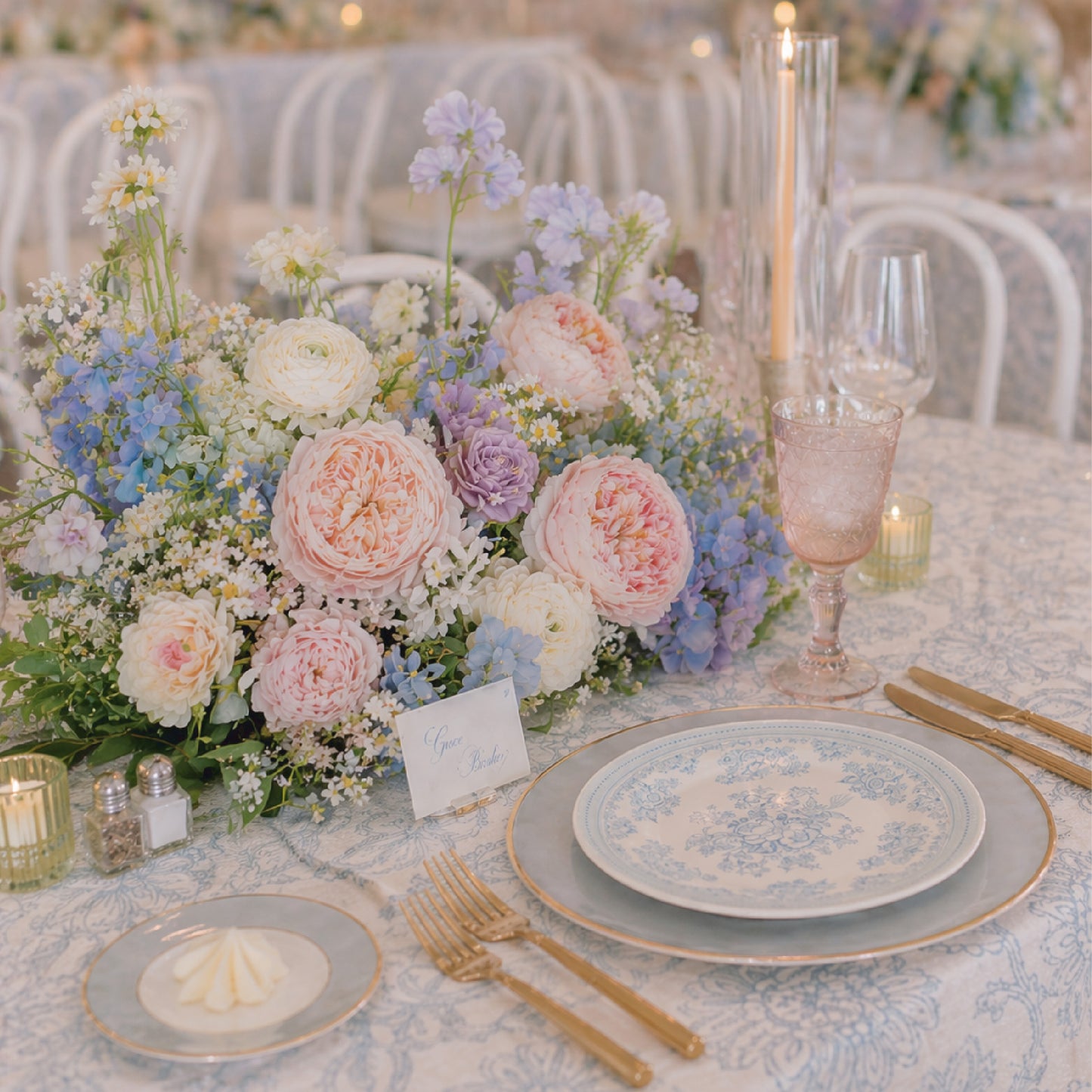 Side view of pastel meadow wedding centerpiece with airy garden flowers in blush and soft blue tones.