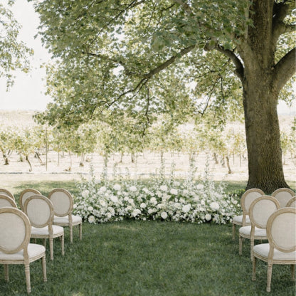 Porcelain Additional Ground Meadow Arrangements lining outdoor ceremony aisle with layered white florals beneath mature trees