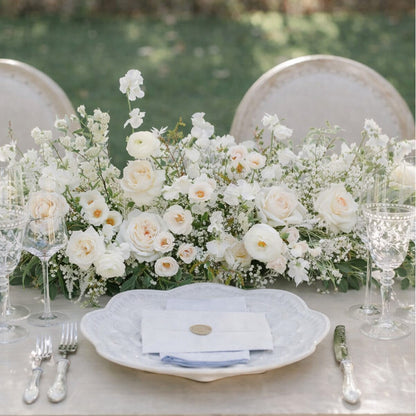 Porcelain Growing Garden Runner with layered white blooms and airy greenery styled across an elegant reception table setting.
