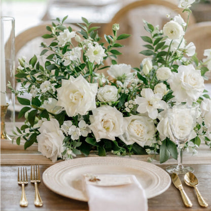 Porcelain Meadow Composition with lush white blooms and foliage arranged in a low, sculptural form on a wedding reception tablescape.