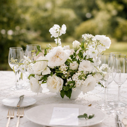 Porcelain small Still Life Vessel Accent with soft white garden blooms arranged in low ceramic bowl centerpiece on elegant reception table.
