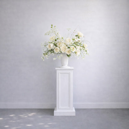 Porcelain Ceremony Urn Arrangement elevated on white pedestal featuring romantic white florals and airy garden-inspired ceremony styling.