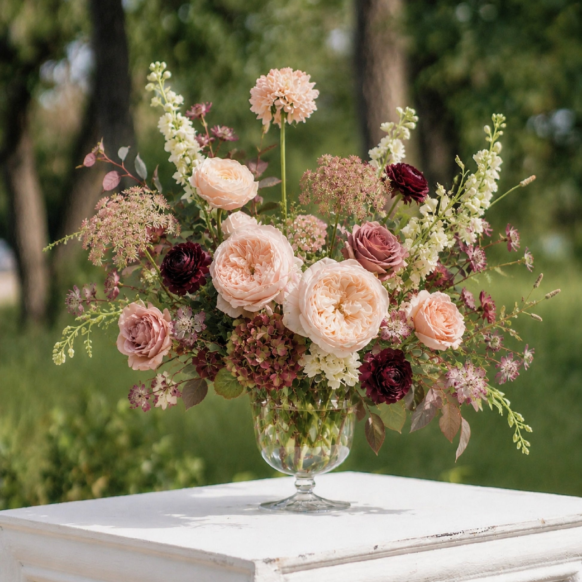 Moody burgundy and mauve glass compote centerpiece with romantic autumn wedding flowers