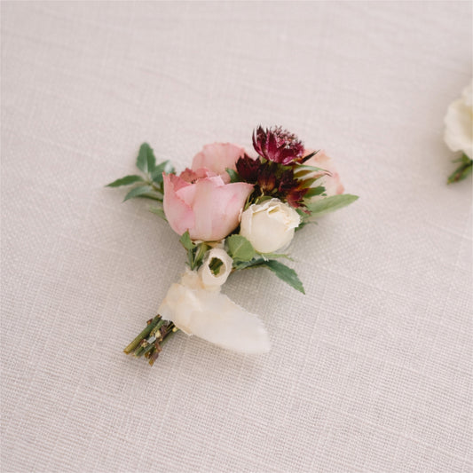A moody boutonnière in burgundy, blush, and warm cream.