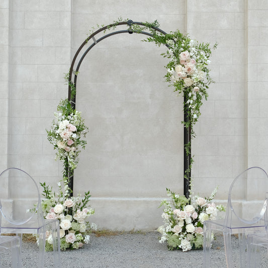 Rosewater ceremony arch floral swags with blush and ivory garden blooms styled on a modern black arbour.