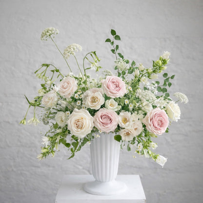 Rosewater ceremony urn arrangement with blush and ivory garden blooms in a classical white urn.
