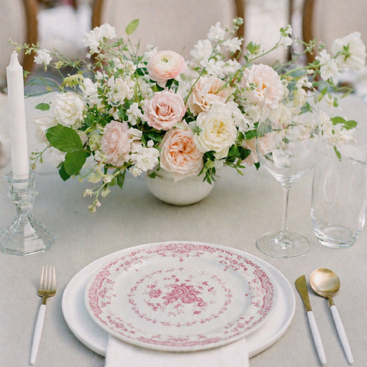 Rosewater small still-life centerpiece with blush and ivory garden blooms arranged in a ceramic bowl on a reception table.