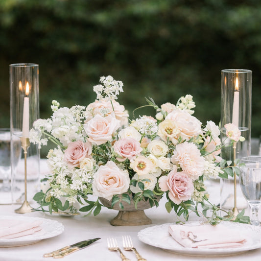 Rosewater heirloom compote centerpiece with blush roses and airy ivory blooms styled on an elegant reception table.
