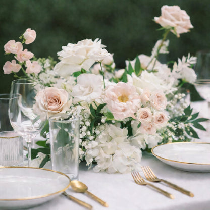 Rosewater meadow composition centerpiece with airy blush and ivory florals arranged on a romantic reception tablescape.